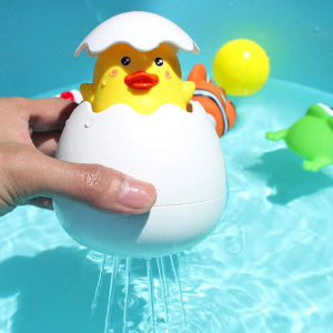 Yellow duck toy in an eggshell being held over a pool with water splashing out.