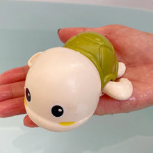 Load image into Gallery viewer, Toy turtle held in a hand against a light background