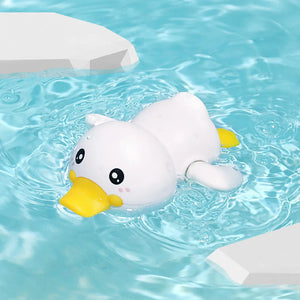 White duck-shaped toy with a yellow beak floating in clear blue water.