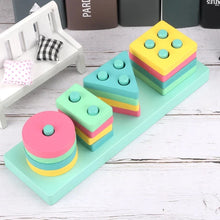 Load image into Gallery viewer, Colorful geometric stacking blocks on a wooden surface with a small toy house in the background.