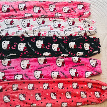Load image into Gallery viewer, Set of Hello Kitty-themed leggings in various patterns on a white surface.