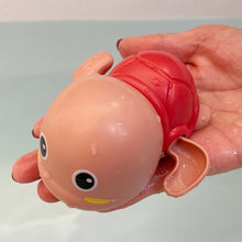 Load image into Gallery viewer, Toy octopus with a red shell held in a hand against a light background