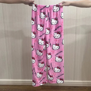 Pink 'Hello Kitty' patterned pants held up against a neutral wall.