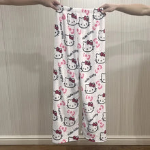 Load image into Gallery viewer, White pants with Hello Kitty pattern held by two hands against a neutral background