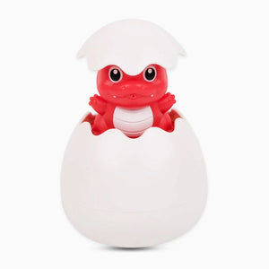 Red dinosaur toy hatching from a white egg on a white background