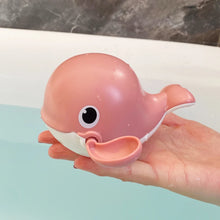 Load image into Gallery viewer, Pink whale-shaped toy held in a hand with a neutral background