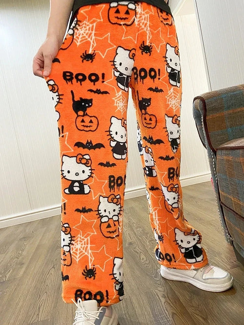 Orange Halloween-themed pants with Hello Kitty design worn by a person indoors.