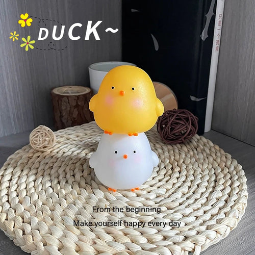 Yellow and white chick-shaped lamp on a woven mat with decorative elements.